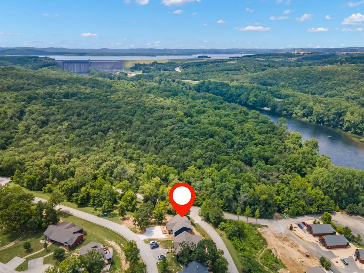 A panoramic view featuring lush green forests, a winding river, a distant lake, and scenic hills. The expansive landscape suggests a range of adventurous activities, such as hiking, fishing, and boating, set against a peaceful, natural backdrop.