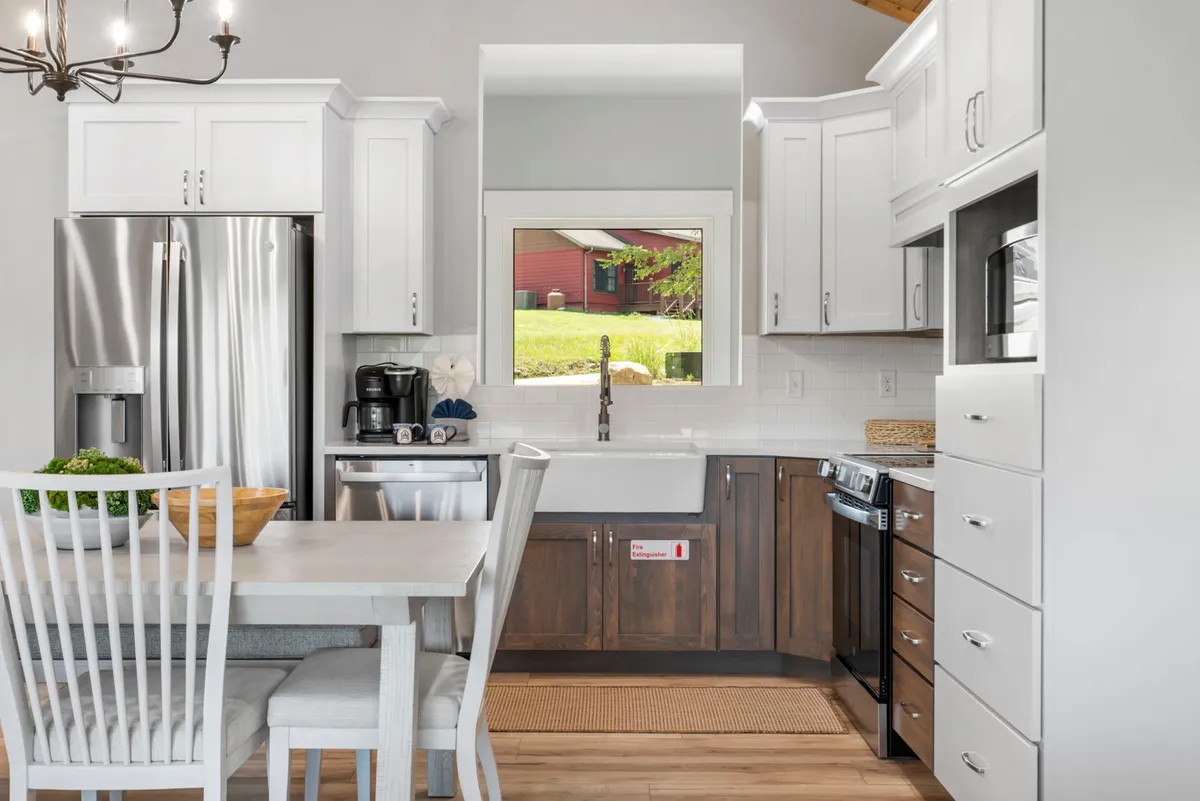 An inviting view of the kitchen and dining area, featuring a spacious dining table set near a window and a modern kitchen island with ample counter space. The atmosphere is warm and conducive to social gatherings, cooking, and shared meals.