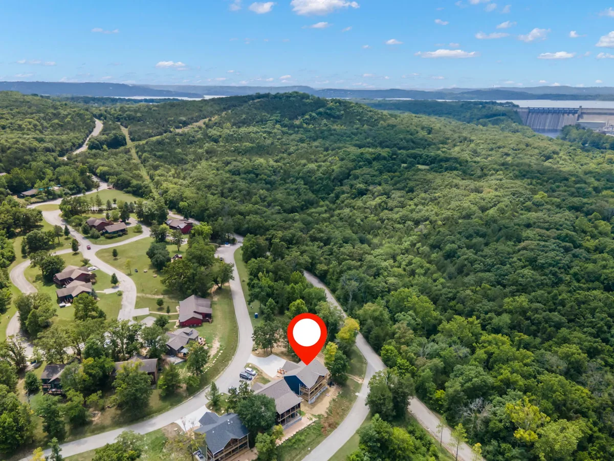A single-family home set against a backdrop of mature trees and lush greenery, with a winding road leading toward outdoor adventures. The porch hints at enjoying the outdoors from the comfort of home.